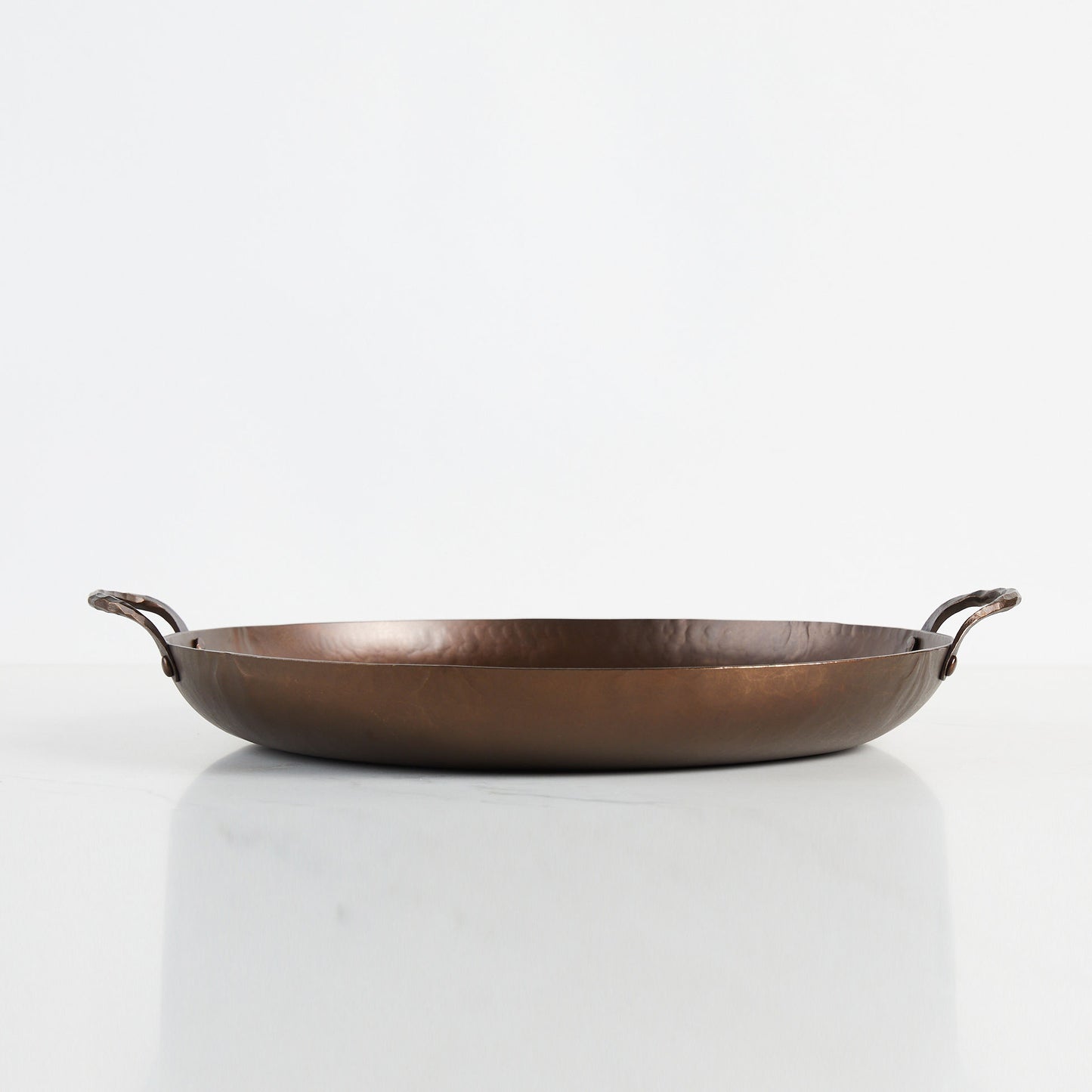 The Smithey party/paella pan is 17" across and holds 7 quarts.