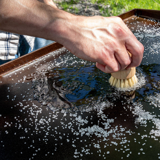 Use a little water and a scrub brush to allow the griddle scrub salt to loose stubborn food.