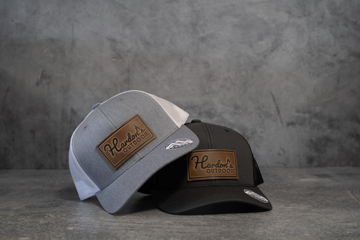 Buy 1 (one) Hardon's Outdoor hat with leather logo in choice of two color combos—heather gray and white, or dark charcoal gray and black.