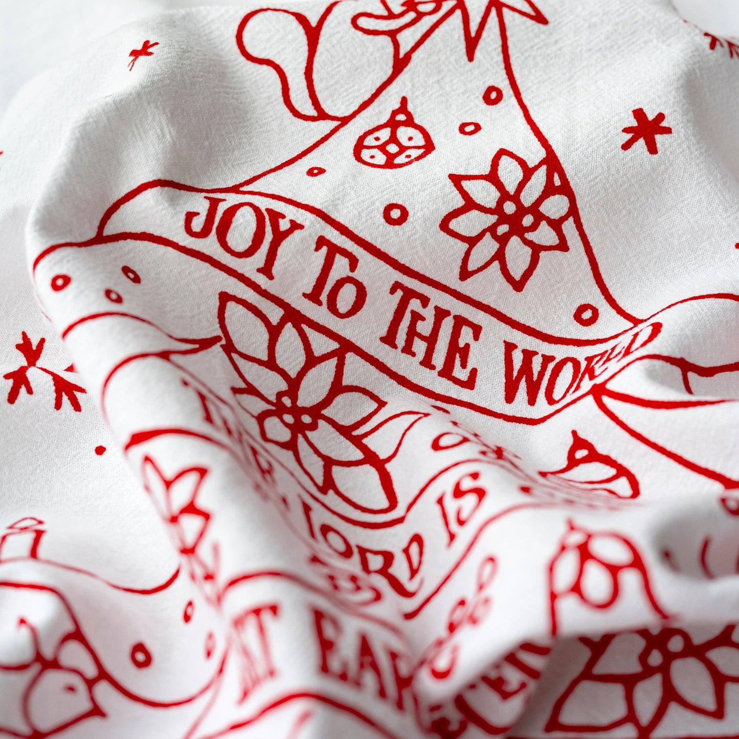 Woodland creatures decorate a tree in the design of this holiday tea towel.