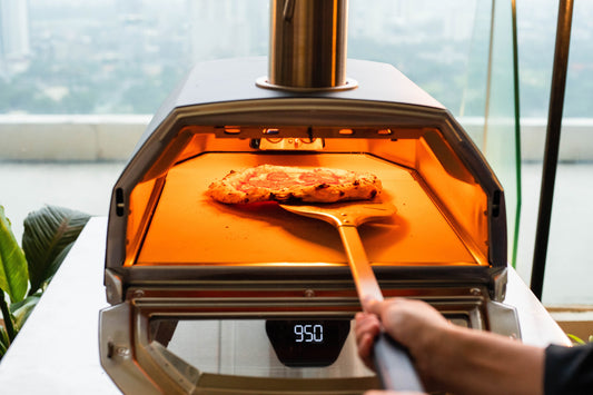 A person using the Ooni turning peel spins the pizza, moving one side closer to the flame.