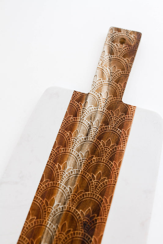 Buy one white marble cutting and serving board with intricately etched acacia wood down the center.