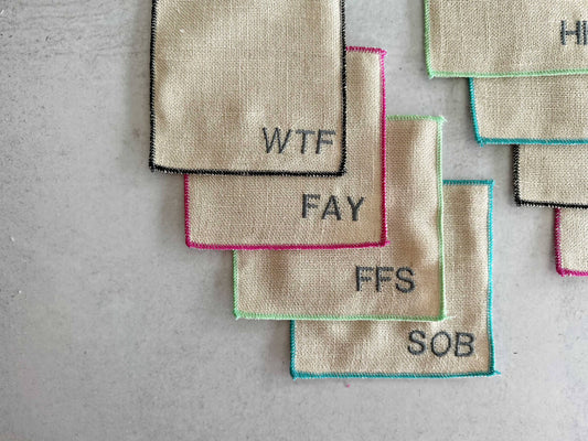 Each coaster is a different color and swear word monogram.
