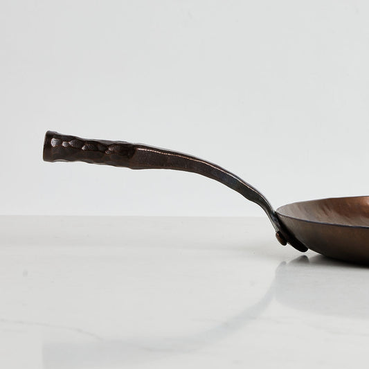 Admire the art of blacksmithing in the hand-forged handle on this Farmhouse 12" skillet.