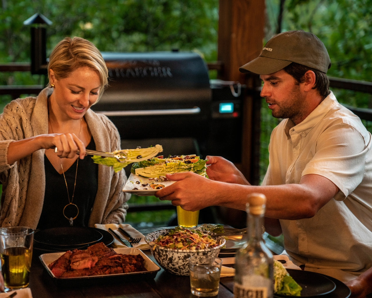 A couple smiles as they start eating dinner. Their tastebuds are awakened by flavorful rubs, seasoning and sauces.