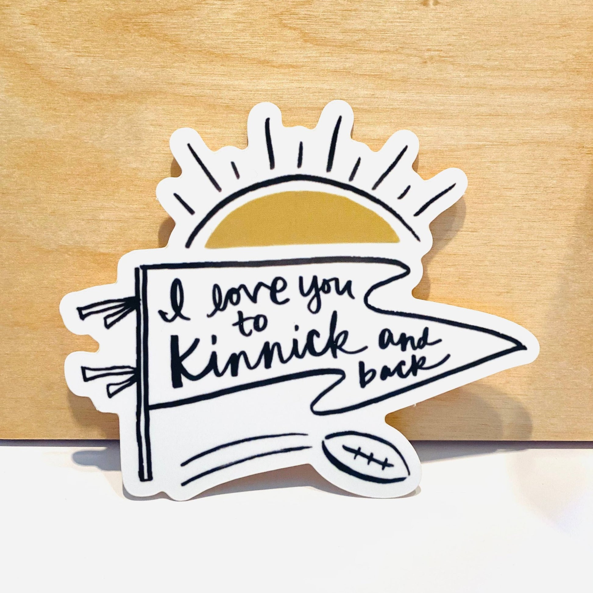 Vinyl sticker shows a pennant with a golden sunrise and says "I love you to Kinnick and back"