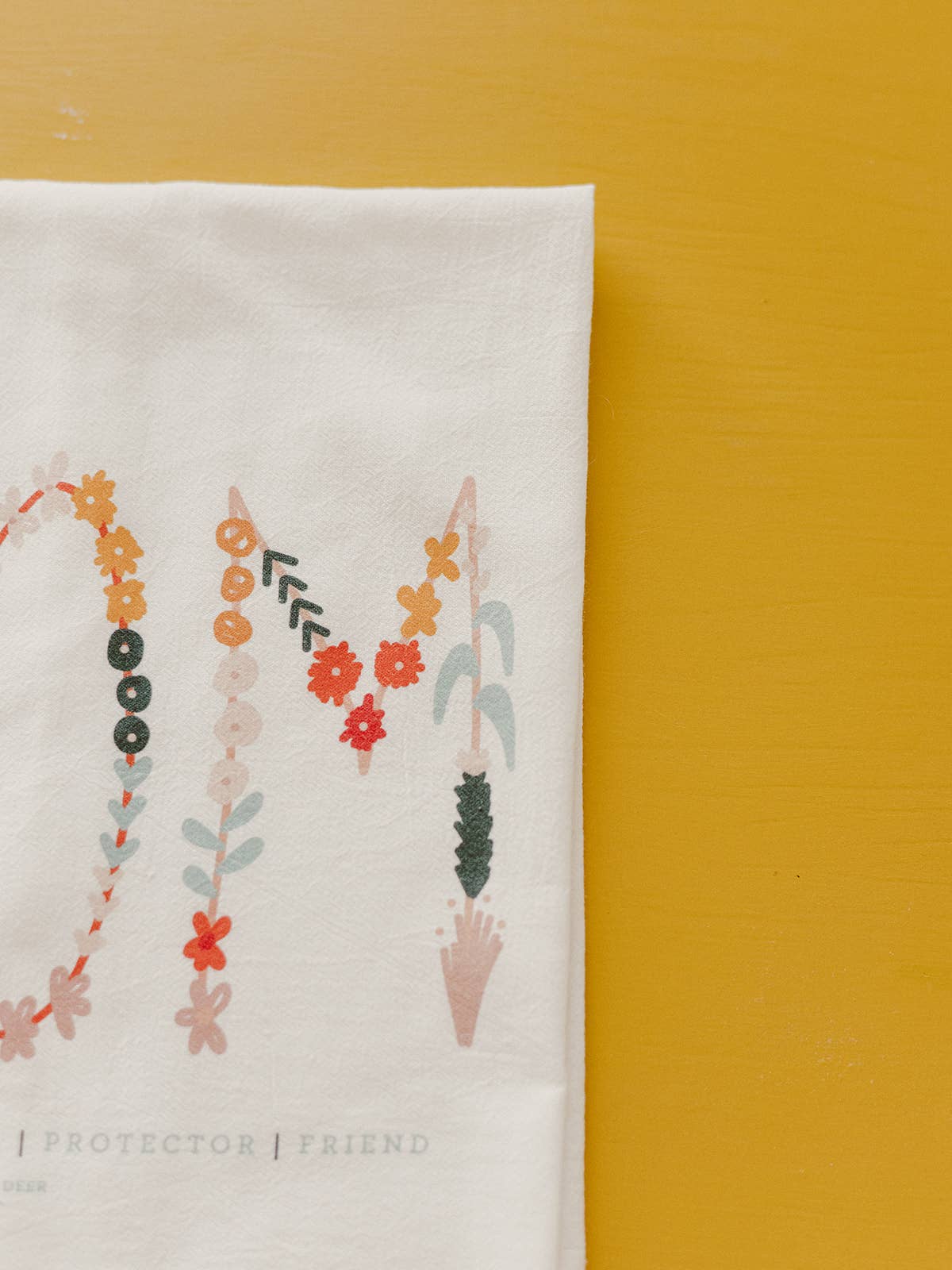This Mother's Day flour sack towel is white cotton with a colorful floral design. 