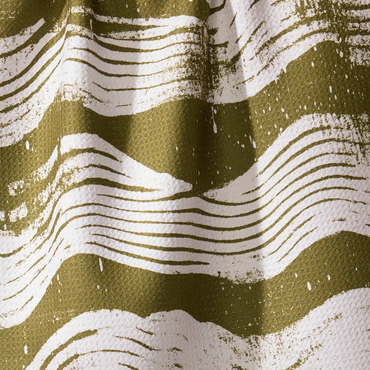 Buy this waffle weave tea towel, with white brushstrokes across a green print. 