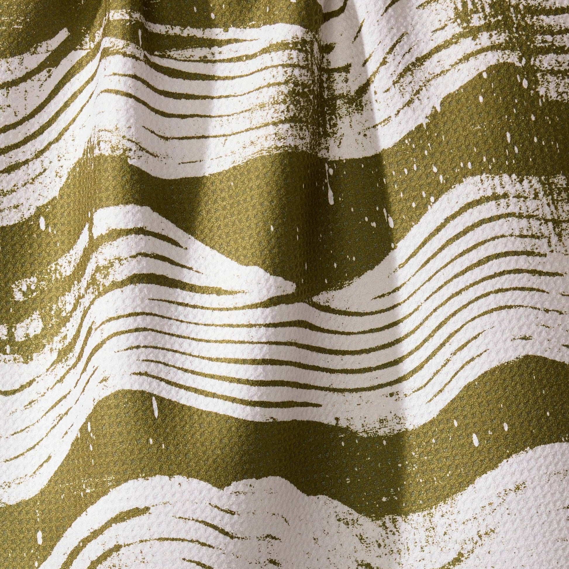 Buy this waffle weave tea towel, with white brushstrokes across a green print. 