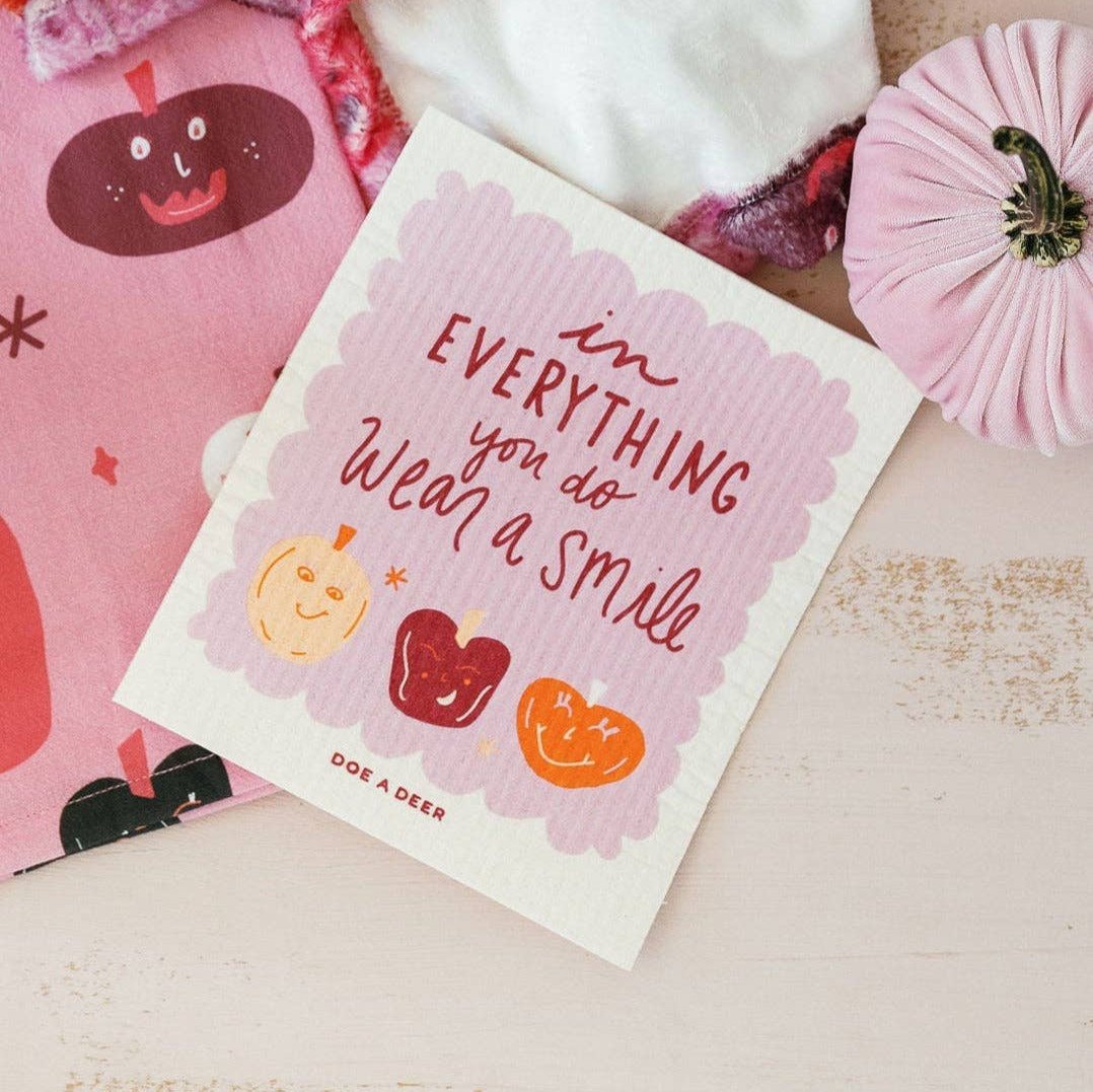 The Swedish dishcloth says, "In everything you do, wear a smile" and matches a halloween tea towel.