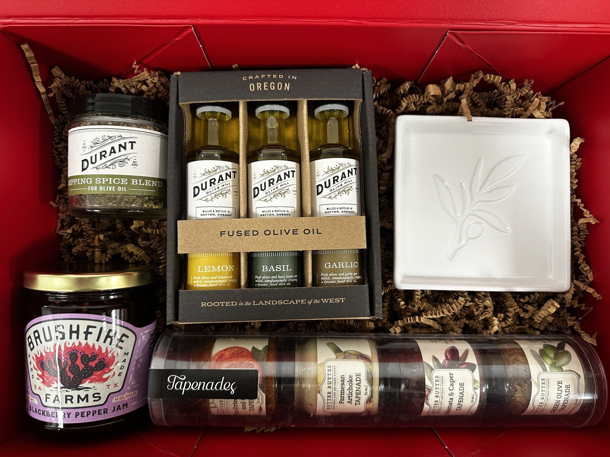 Buy 1 (one) food gift bundle with flavored olive oils, dipping spices, blackberry pepper jam, four tapenade flavors, and a ceramic plate for dipping bread into olive oil. 