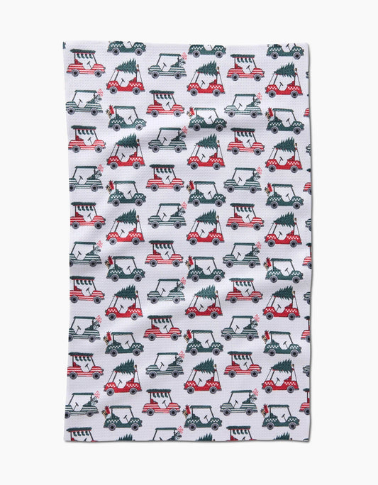 Buy 1 (one) tea towel featuring golf carts carrying trees and decorated for the holidays. 