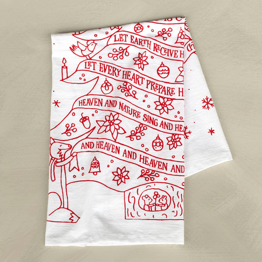 A white towel with red print incorporates lyrics from the song, "Joy to the World," into the beautiful design. 