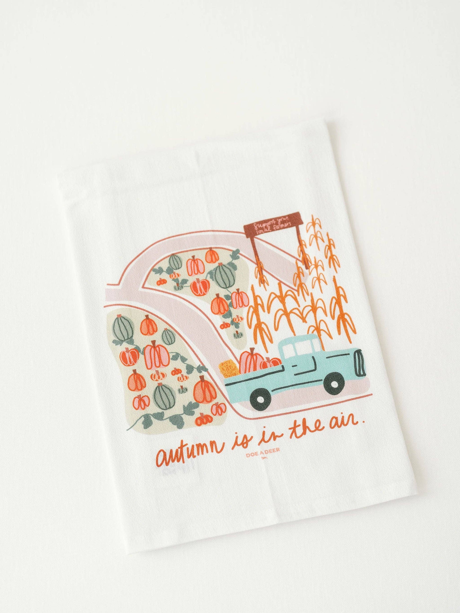 Buy one 100% cotton tea towel white, with colorful fall pumpkin stand print.