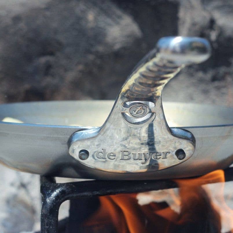 The de Buyer MINERAL B Pro skillet cooking over an open flame.