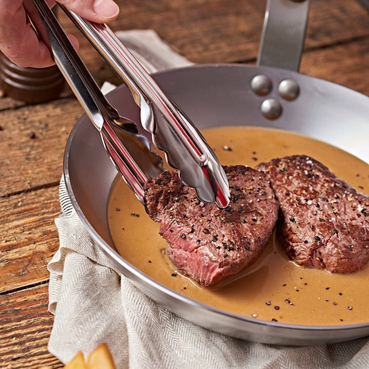 Finishing steaks in rich sauce in a de Buyer MINERAL skillet. 